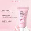 A pink tube of Japan Sakura Cleanser facial cleanser with a white lid and a dollop of foam on a pink surface.