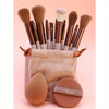 A collection of fifteen makeup brushes in various shades and sizes displayed on a pink background.