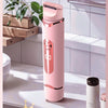 A pink electric shaver with white shaving leaves is shown on a bathroom counter.