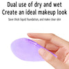 A hand holds a purple beauty sponge, demonstrating its use for makeup application.