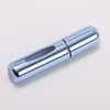 A silver portable refillable perfume bottle with a cylindrical body and a clear glass insert.