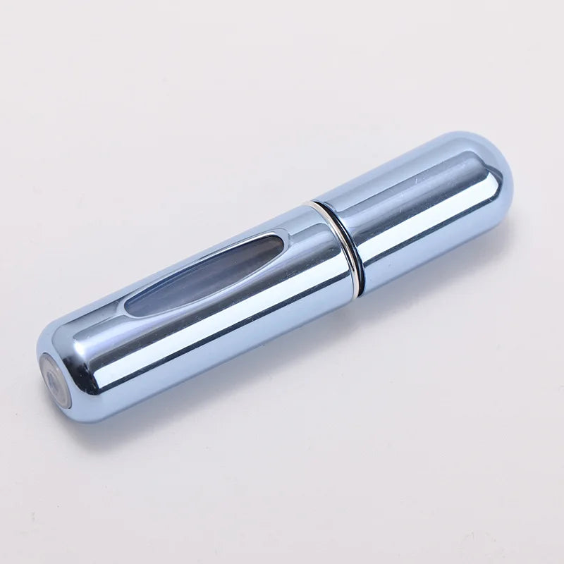 A silver portable refillable perfume bottle with a cylindrical body and a clear glass insert.