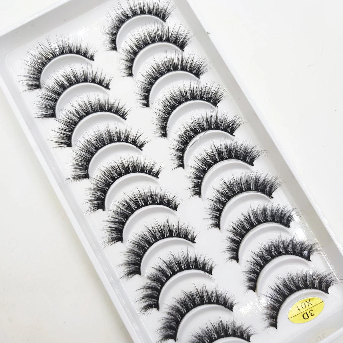A plastic tray holding various styles of black natural 3D mink false eyelashes.