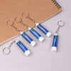 Several blue nasal relief sticks with metal loops are displayed on a brown notebook.