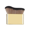 A precision hand-held foundation makeup brush with dark brown and blonde bristles set in a gold rectangular holder.