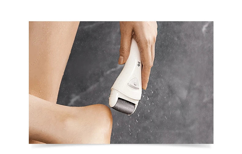 Una mano está usando un exfoliador y lima eléctrica blanca en la pierna de una persona.