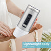 A hand holds a clear, handheld oral irrigator device against a light pink purse.