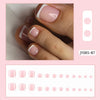 Ein Set wiederverwendbarer falscher Nägel in rosa und weißer French-Design auf einer Hand.