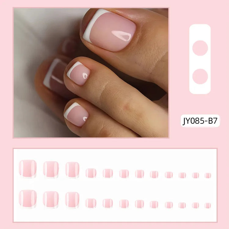 Ein Set wiederverwendbarer falscher Nägel in rosa und weißer French-Design auf einer Hand.