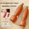 A wooden eye massager tool with brass tips is shown next to a close-up of facial massage and dark circles treatment.