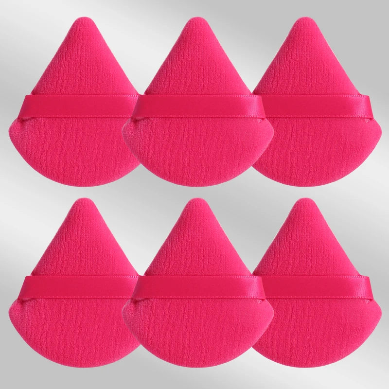 Un set de six puffs de maquillage triangulaires roses vifs avec des bandes en silicone rose.