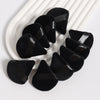 Un ensemble de tampons de poudre noirs triangulaires disposés sur un plat blanc.