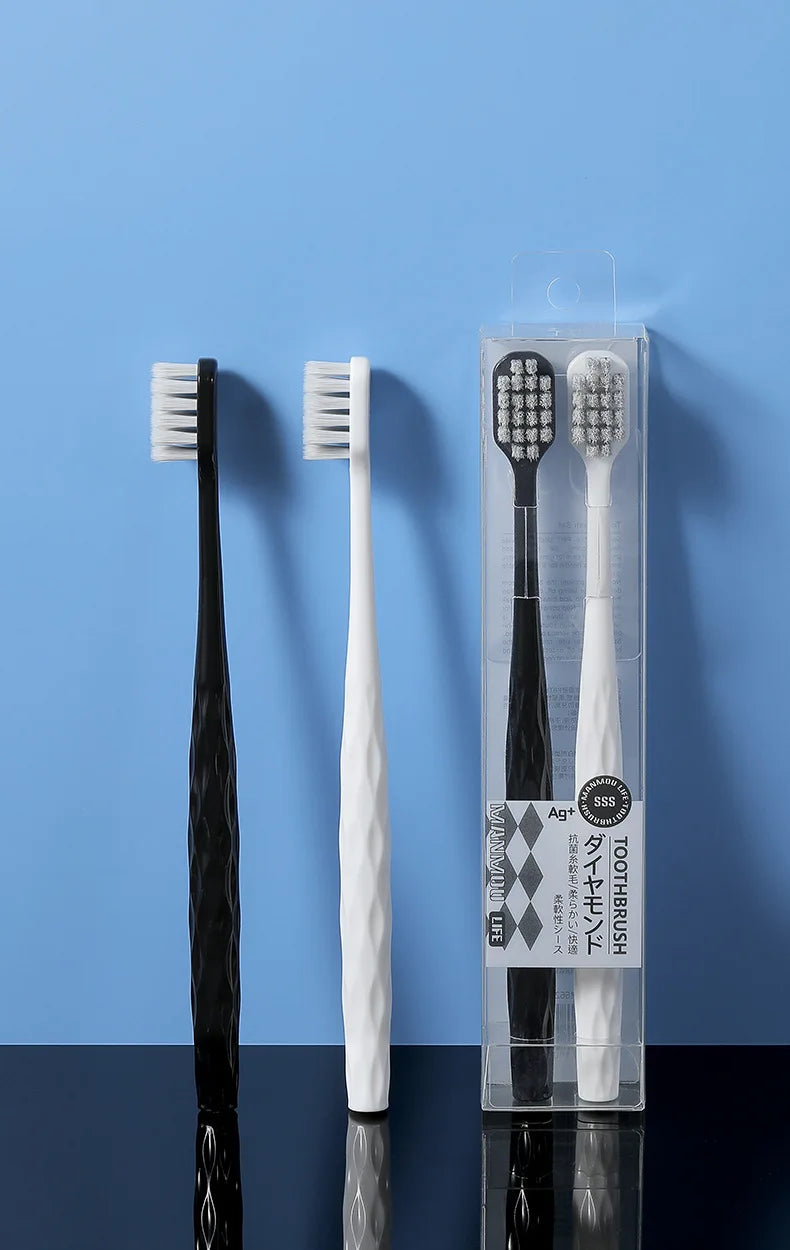 Un set de deux brosses à dents antibactériennes blanches et noires.
