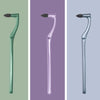 Three versions of a manual tooth stain remover with an interdental brush in green, purple, and silver.