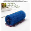 A rolled blue exfoliating sponge with a purple and white striped band is shown on a white surface.