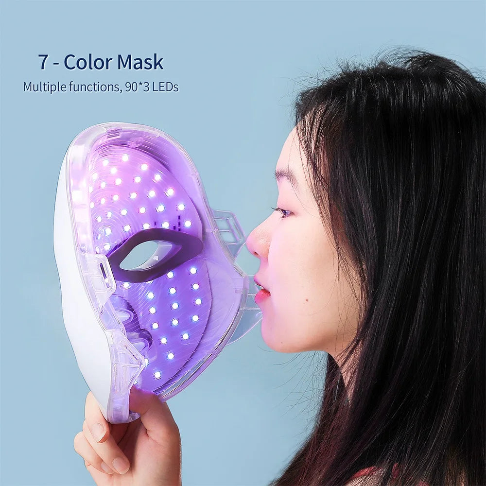 Eine Frau verwendet eine lila LED-Gesichtsmaske auf ihrem Gesicht.