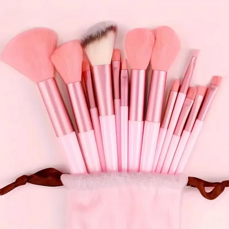 A collection of pink makeup brushes with fluffy and tapered bristles arranged in a display.