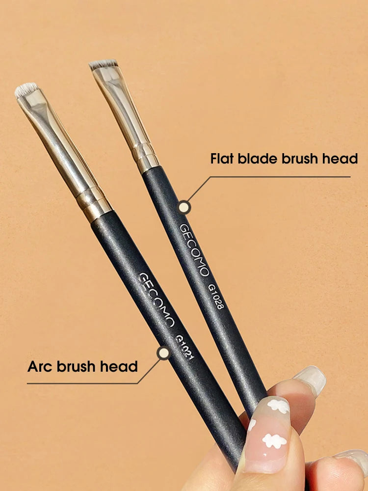 A pair of GECOMO precision makeup brushes, including a flat blade head and an arc brush head, are shown being held by a hand.
