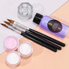 A professional acrylic nail powder kit featuring a purple bottle of monomer liquid and several brushes on a beige surface.