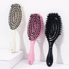Three hair styling combs in black and pink bristles displayed on a white surface.