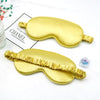 Golden silk eye masks for sleep and relaxation displayed on a white background.