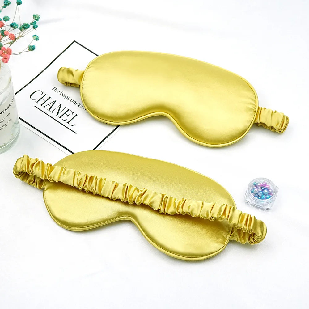 Golden silk eye masks for sleep and relaxation displayed on a white background.