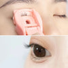 A pink cartoon mini eyelash curler is shown in two views: a close-up of the device and an application on an eye.