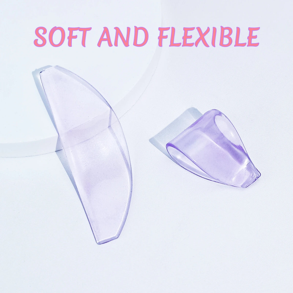 A pair of translucent purple silicone lash lift pads are shown against a white background.