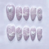 A collection of 24 pink heart pearl press-on fake nails displayed on a white background.