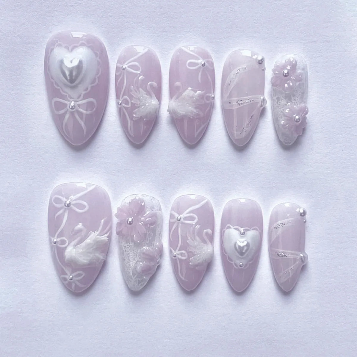 A collection of 24 pink heart pearl press-on fake nails displayed on a white background.