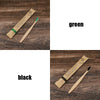 A set of eco-friendly bamboo toothbrushes in green and black are shown on a wooden surface.