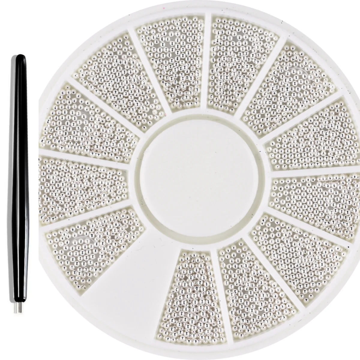 A circular plate of mixed stainless steel beads used for nail art decorations, with a black tool next to it.