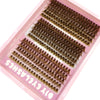Un plateau rose contient des extensions de faux cils naturels et fins pour application DIY.
