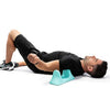 A man lying on his stomach receiving deep tissue massage on his thigh with a blue muscle massager.