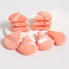 Un ensemble de puffs triangulaires roses avec des accents de ruban satiné, arrangés sur un plat blanc.