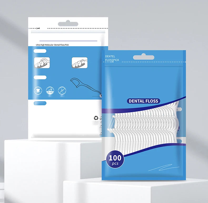 A package of dental floss and plastic toothpicks is displayed on a white surface.