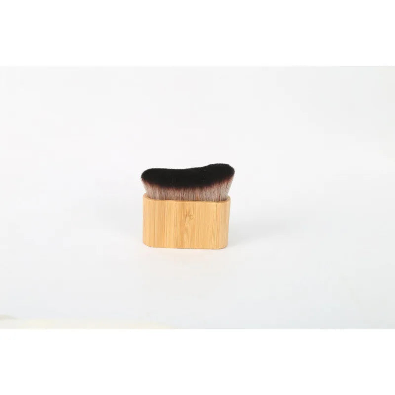 A small wooden brush with dark bristles used for applying tan and foundation.