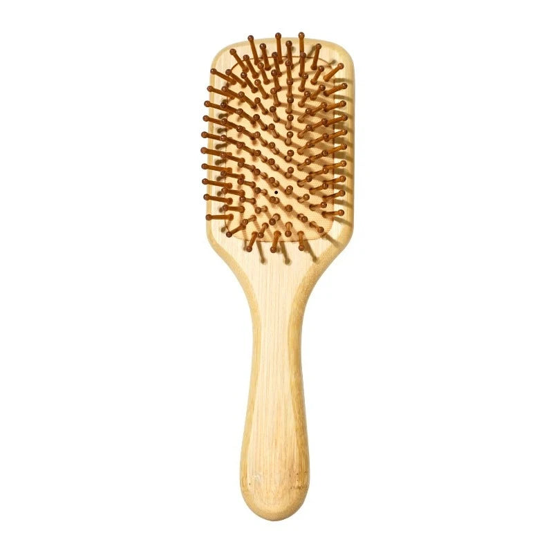 A light wood bamboo comb with numerous fine teeth used for scalp and hair growth.