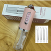 A pink portable electric oral irrigator device with various tips is shown next to its packaging.