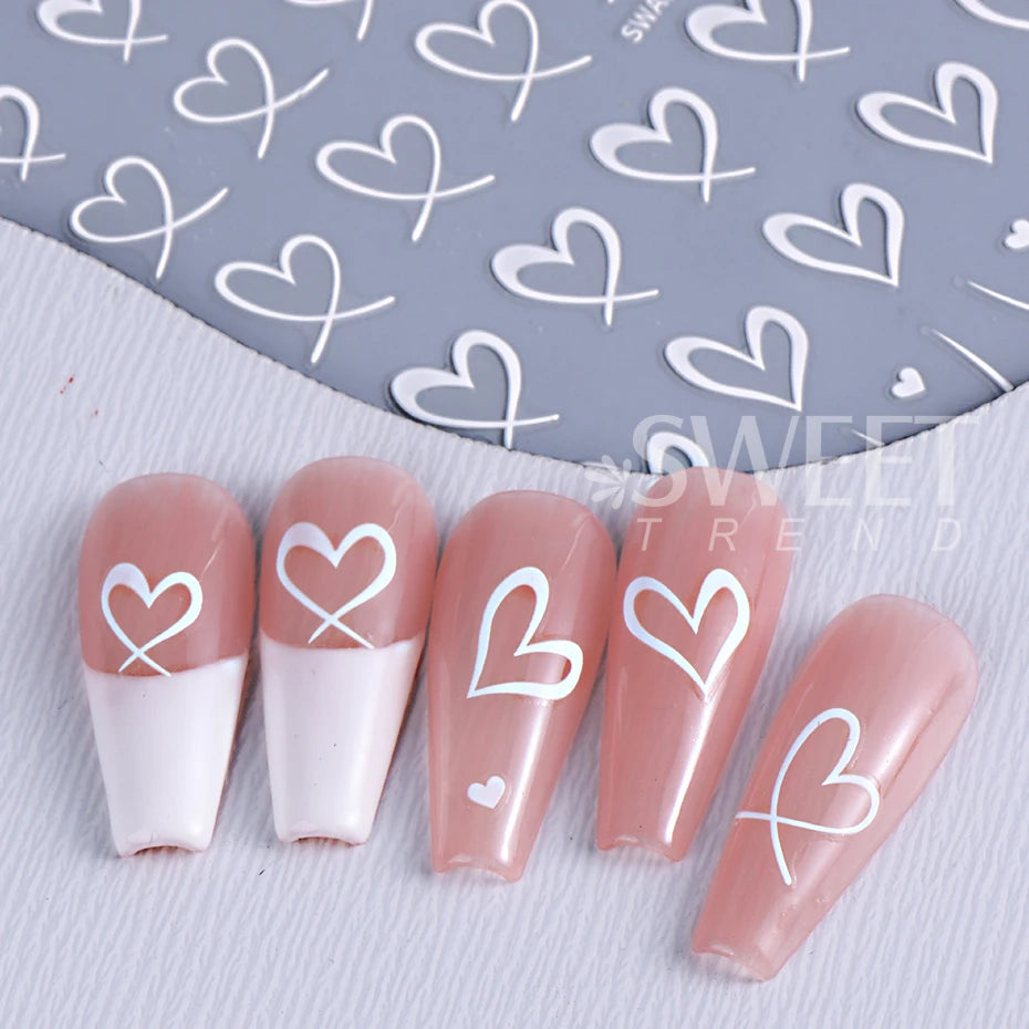 Un ensemble de décals à ongles rose et blanc avec de petits cœurs sur fond gris pour manucure DIY