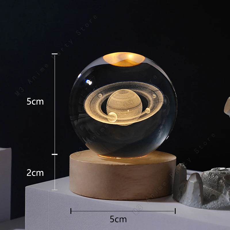 A clear glass crystal ball night light rests on a wooden base, illuminated from within.