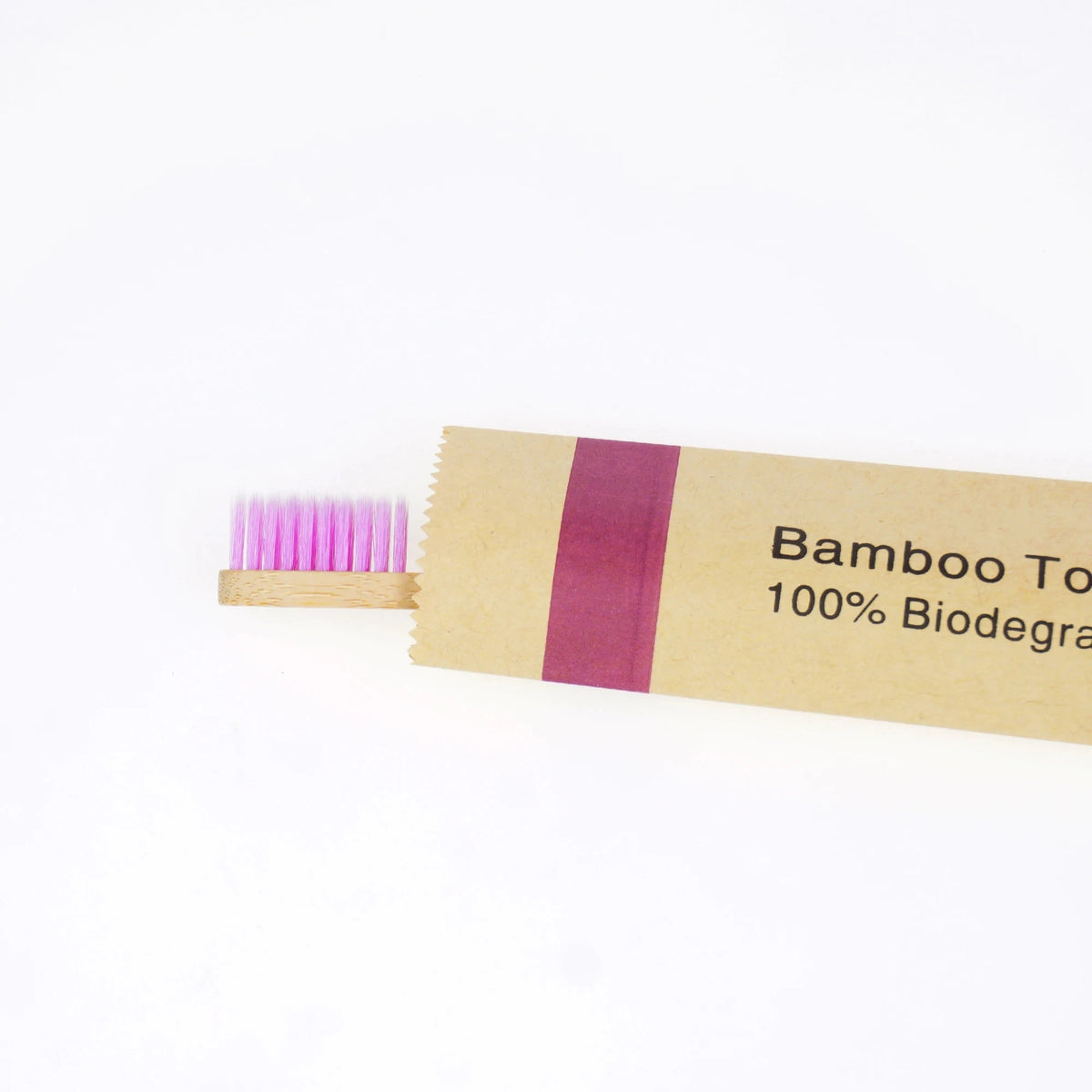 A package of bamboo toothbrushes with soft pink bristles and a label reading Bamboo Toothbrushes 100% Biodegradable.