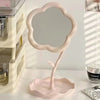 Miroir de bureau floral rose avec cadre festonné, posé sur une surface blanche.