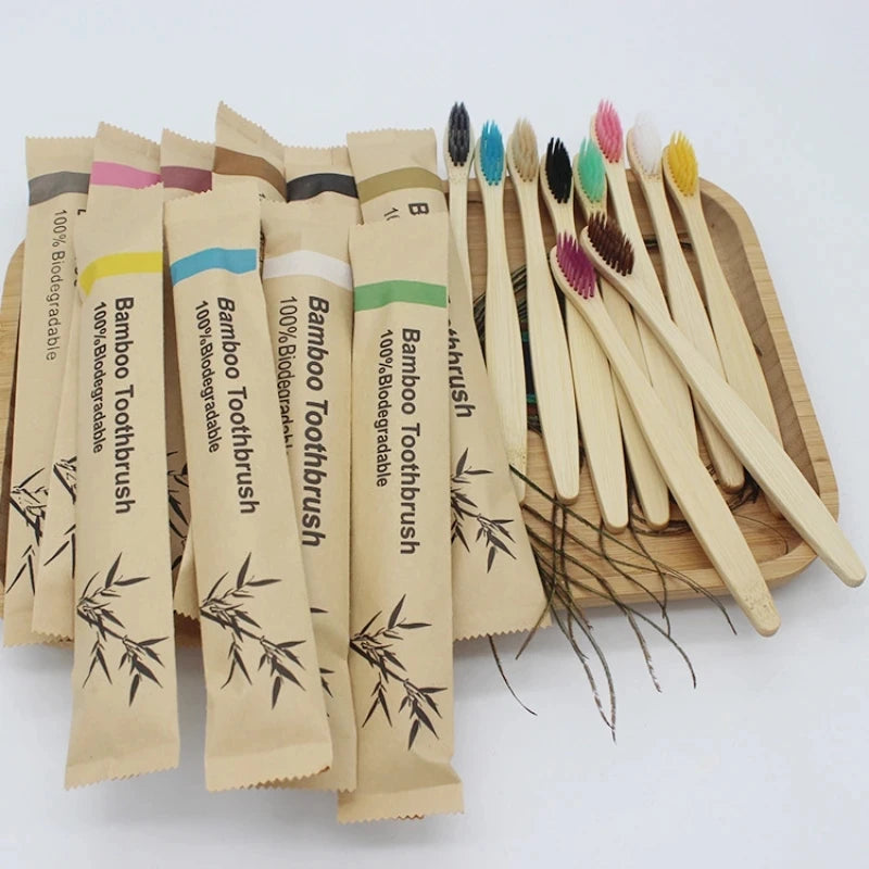 A collection of 100 eco-friendly bamboo toothbrushes with various colored bristles displayed on a wooden board.