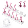 A set of pink magnetic nail art display stands and a clear ring displayed on a white wooden board.