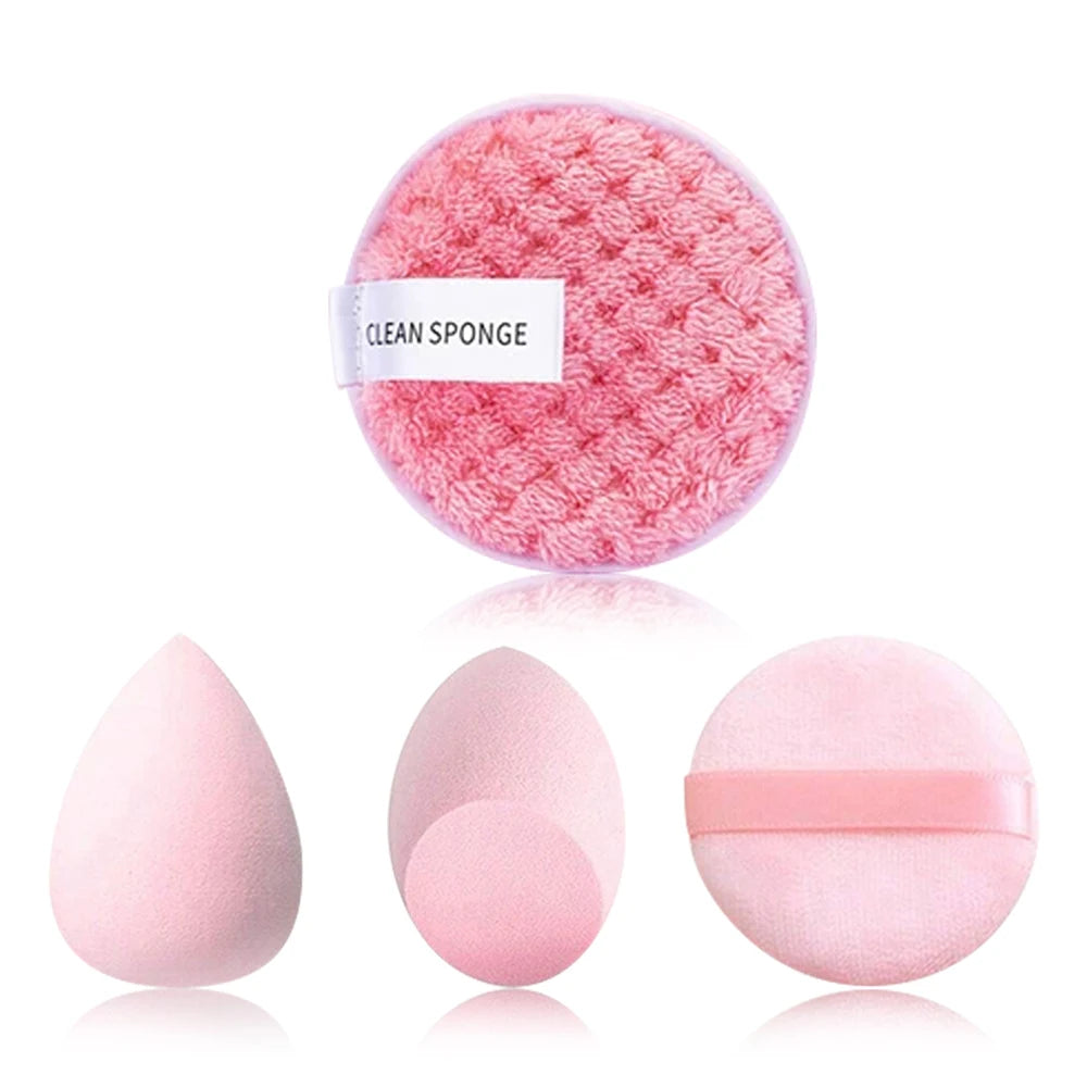 A pink cleaning sponge and three pink beauty sponges are displayed on a white background.