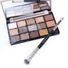 A double-ended eye shadow brush with a smudge tip and blending shader is shown in an open makeup palette.