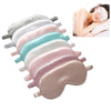 Une pile de masques de sommeil en soie imitation de diverses nuances pastel, y compris rose et bleu, à côté d'une femme qui s