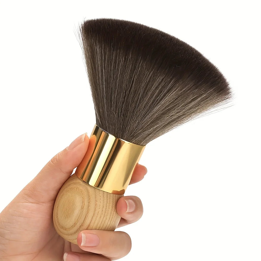 A hand holds a professional hair duster brush with a wooden handle and dark bristles.