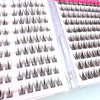 A close-up view of adhesive-free natural look eyelash clusters displayed on a clear plastic tray.